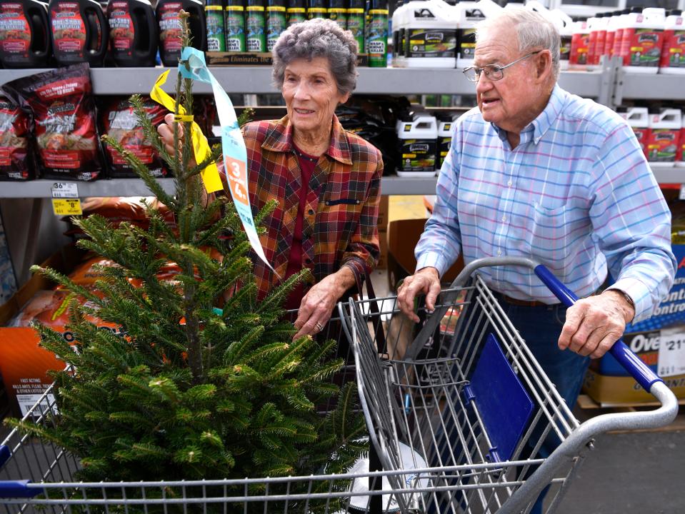 Harold and Betty Sloan look over the small Christmas tree they selected at the south side Lowe's on Tuesday.