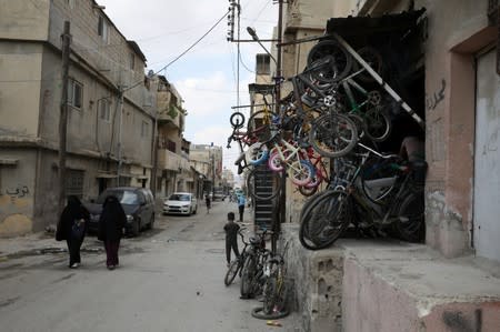 Palestinian refugee women walk at the street in Al-Baqaa Palestinian refugee camp, near Amman