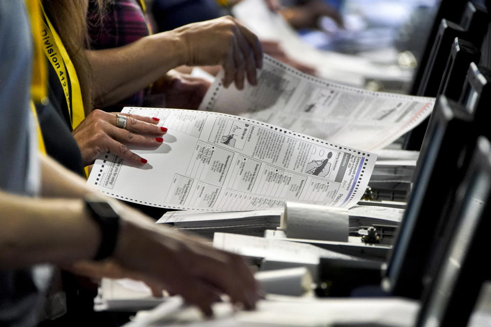 FILE - Election workers perform a recount of ballots from the recent Pennsylvania primary election at the Allegheny County Election Division warehouse on the Northside of Pittsburgh, June 1, 2022. Unlike in many other countries, elections in the U.S. are highly decentralized, complex and feature a long list of races on the ballot, from president or Congress all the way down to local ballot measures or town council seats. Rules also vary greatly by state. Some give local election offices several weeks before Election Day to process mailed ballots, which includes steps that may include checking signatures or ID information. (AP Photo/Gene J. Puskar, File)