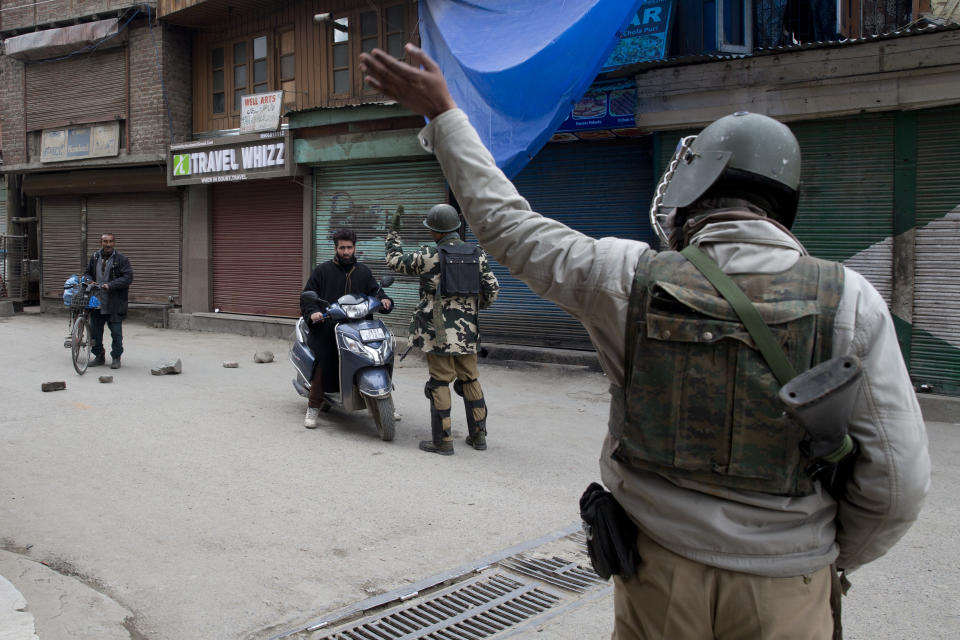 Indian paramilitary soldiers gesture to commuters to turn back during a security lockdown in downtown Srinagar, Indian controlled Kashmir, Friday, March 1, 2019. India has banned Jama'at-e-Islami, a political-religious group in Kashmir, in a sweeping and ongoing crackdown against activists seeking the end of Indian rule in the disputed region amid the most serious confrontation between India and Pakistan in two decades. (AP Photo/ Dar Yasin)