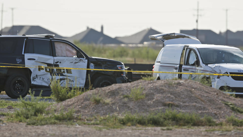 A city of Odessa police car, left, and a U.S. mail vehicle, right, which were involved in Saturday's shooting, are pictured outside the Cinergy entertainment center, Sunday, Sept. 1, 2019, in Odessa, Texas. The death toll in the West Texas shooting rampage increased  Sunday as authorities investigated why a man stopped by state troopers for failing to signal a left turn opened fire on them and fled, shooting over a dozen people as he drove before being killed by officers outside a movie theater.  (AP Photo/Sue Ogrocki)
