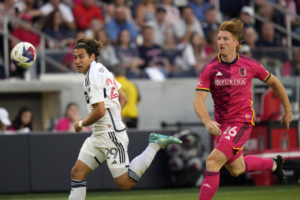 Vancouver Whitecaps' Simon Becher (29) and St. Louis City's Tim Parker (26) chase after a loose ball during the first half of an MLS soccer match Saturday, May 27, 2023, in St. Louis. (AP Photo/Jeff Roberson)