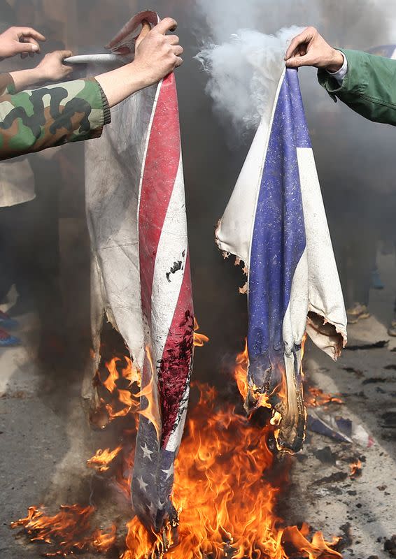 Demonstrators burn Israeli and US flags during a protest over the death of Iranian Major-General Soleimani, who was killed in air strike near Baghdad, in Tehran