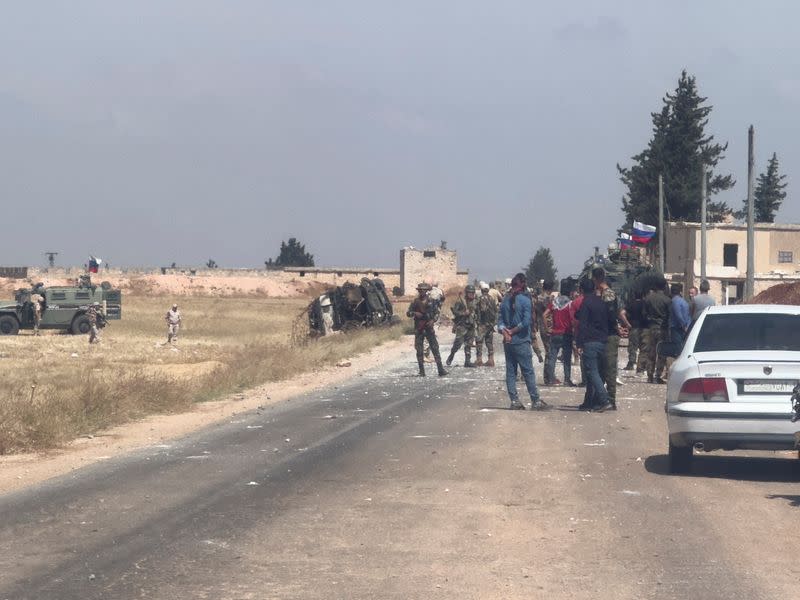 Russian military vehicles are parked near an overturned military vehicle, following an attack that the Syrian Observatory for Human Rights said was caused by Turkish shelling near Tal Rifat