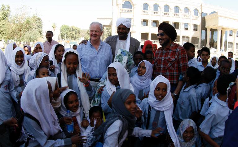 Robert Gordon (C-L), a relative of General Charles Gordon, is greeted by Abdel Rahman Sadiq Al-Mahdi (C), one of the Mahdi's descendants, and local school girls, upon his arrival at Khartoum's Republican Palace, on February 7, 2014