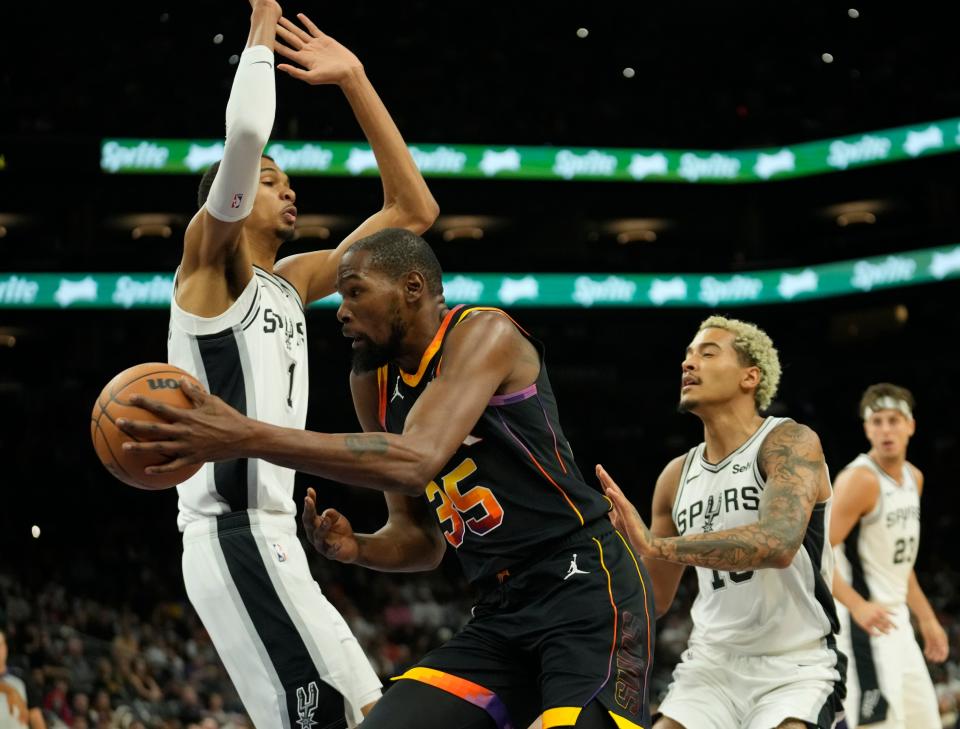 Phoenix Suns forward Kevin Durant (35) passes the ball around San Antonio Spurs center Victor Wembanyama (1) during the first quarter at Footprint Center in Phoenix on Oct. 31, 2023.