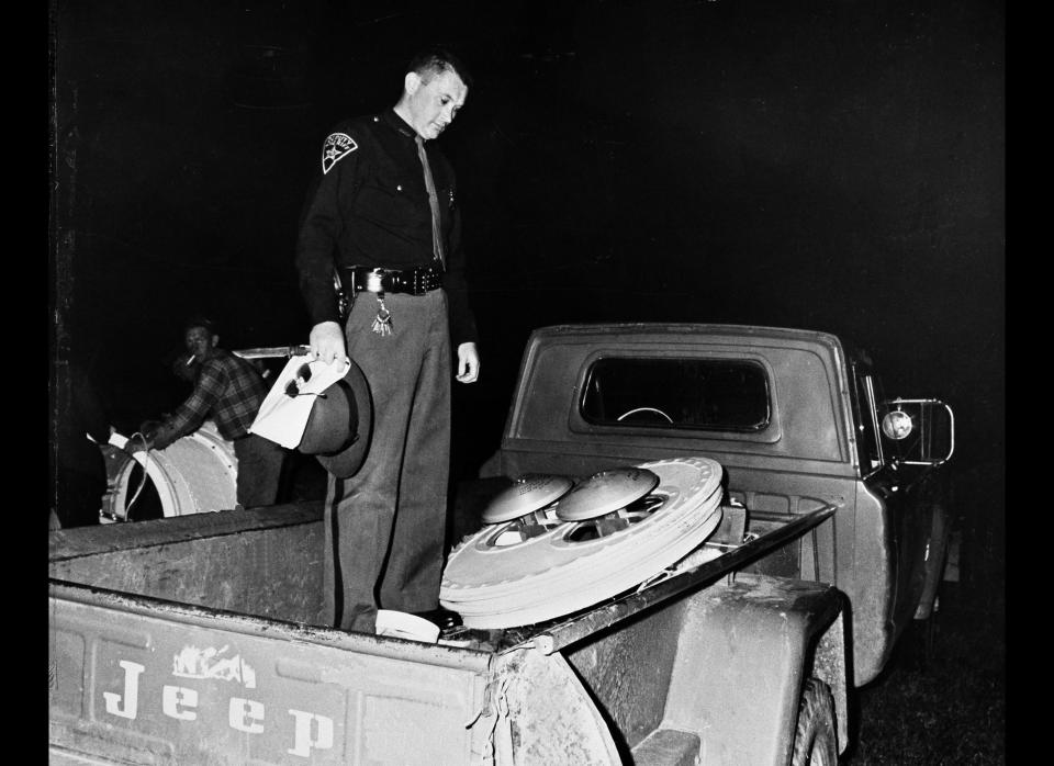 Pickaway County Deputy Sheriff John Wolford supervises the loading of a part from an Air Force balloon that descended from the sky in south central Ohio farmland, April 19, 1966. The balloons, devices and a 4,500-pound payload apparatus, launched at Holoman Air Force Base, N.M., came down in two sections about 15 miles apart. (AP Photo)
