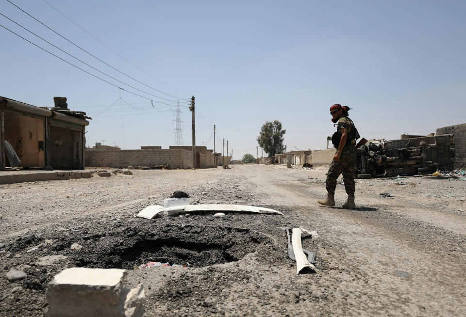 SDF fighter walks past a crater