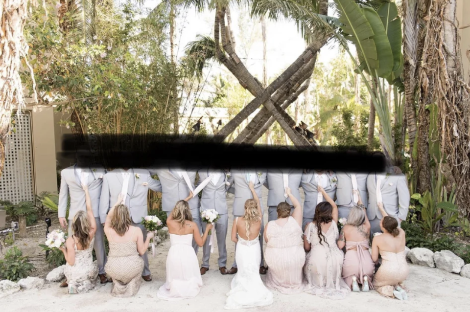 Bridesmaids and the bride kneeling in front of the groomsmen