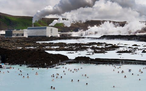 This picture taken on August 4, 2010 shows tourists at the Blue Lagoon in Svartsendi, Iceland next to the Svartsengi Power Station - Credit: AFP