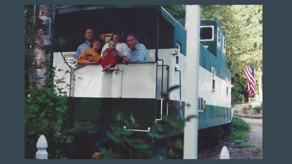 Hugh McMillan used a damaged train caboose as a home office after he moved it to his property and restored it. With him are Janice, Lance, daughter-in-law Sheri Ahlheim and grandson Cameron.