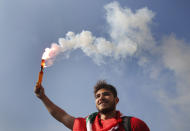 A student protester holds a smoke flare during a protest against the government in front of the education ministry in Beirut, Lebanon, Friday, Nov. 8, 2019. Lebanese protesters are rallying outside state institutions and ministries to keep up the pressure on officials to form a new government to deal with the country's economic crisis. (AP Photo/Hussein Malla)