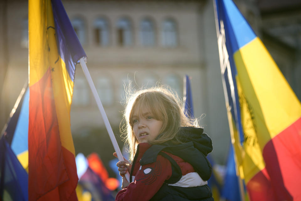 A little girl waves a flag during an anti-government and anti-restrictions protest organised by the far-right Alliance for the Unity of Romanians or AUR, in Bucharest, Romania, Saturday, Oct. 2, 2021. Thousands took to the streets calling for the government's resignation, as Romania reported 12.590 new COVID-19 infections in the past 24 hour interval, the highest ever daily number since the start of the pandemic. (AP Photo/Vadim Ghirda)