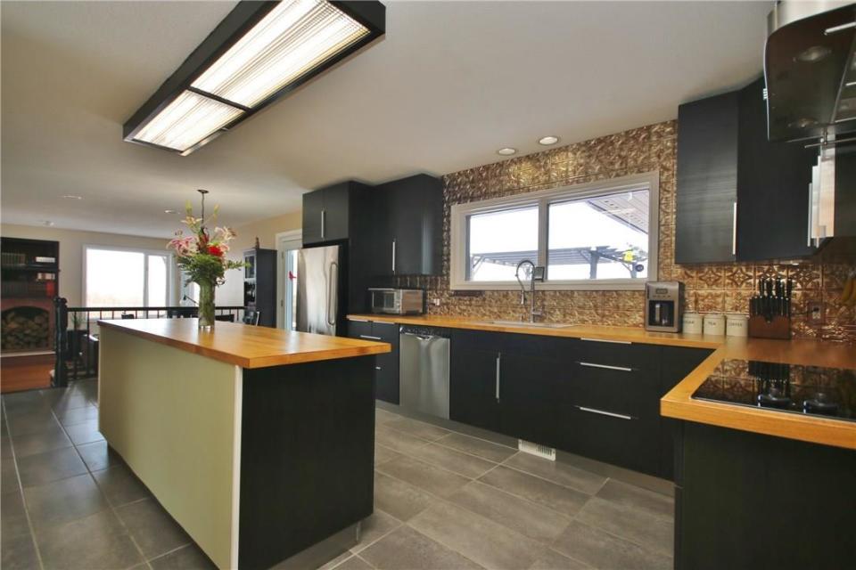 <p><a rel="nofollow noopener" href="https://www.zoocasa.com/ottawa-on-real-estate/5004937-2955-quillivan-lane-ottawa-on-k4c1a9-1087340" target="_blank" data-ylk="slk:2955 Quillivan Drive, Ottawa, Ont.;elm:context_link;itc:0;sec:content-canvas" class="link ">2955 Quillivan Drive, Ottawa, Ont.</a><br> The kitchen includes the fridge, built-in cooktop, dishwasher, and combination microwave range hood, and can be accessed via a small elevator from the garage.<br> (Photo: Zoocasa) </p>