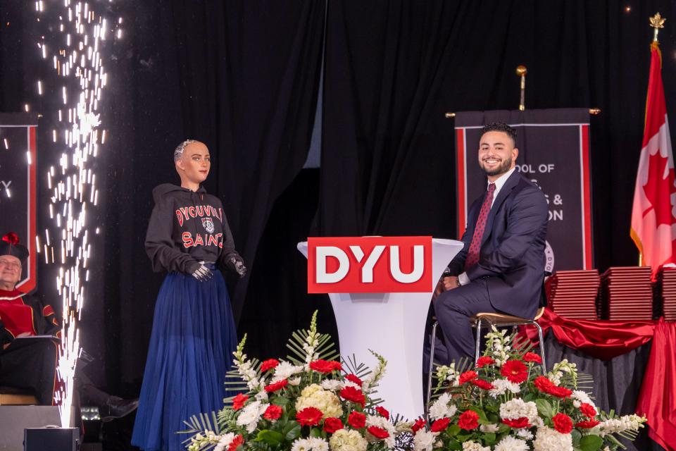 Sophia the humanoid robot and John Rizk, D’Youville University Student Government Association president, at the private institution's spring commencement ceremony on May 11, 2024.