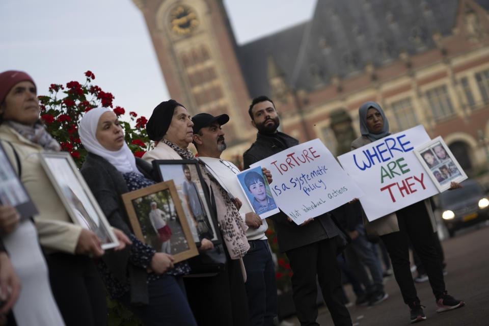 FILE - Demonstrators display pictures of people, they say disappeared in Syria, outside the International Court of Justice, or World Court, in The Hague, Netherlands, Tuesday, Oct. 10, 2023. The United Nations' top court on Thursday ordered the Syrian government to “take all measures within its powers” to prevent torture, in a case in which the Netherlands and Canada accuse Damascus of a years-long campaign of torturing its own citizens. (AP Photo/Peter Dejong, File)