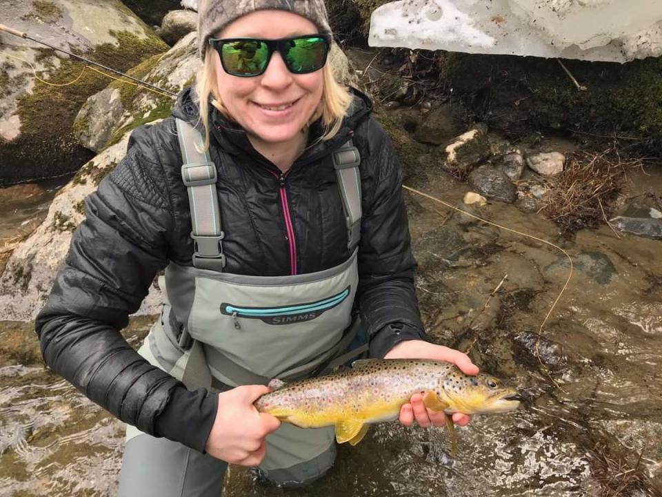 Photo of Stephanie Olsen, an employee at Stowe's Fly Rod Shop, with a catch. Olsen's passion for protecting wildlife and promoting sustianability informs her fishing.