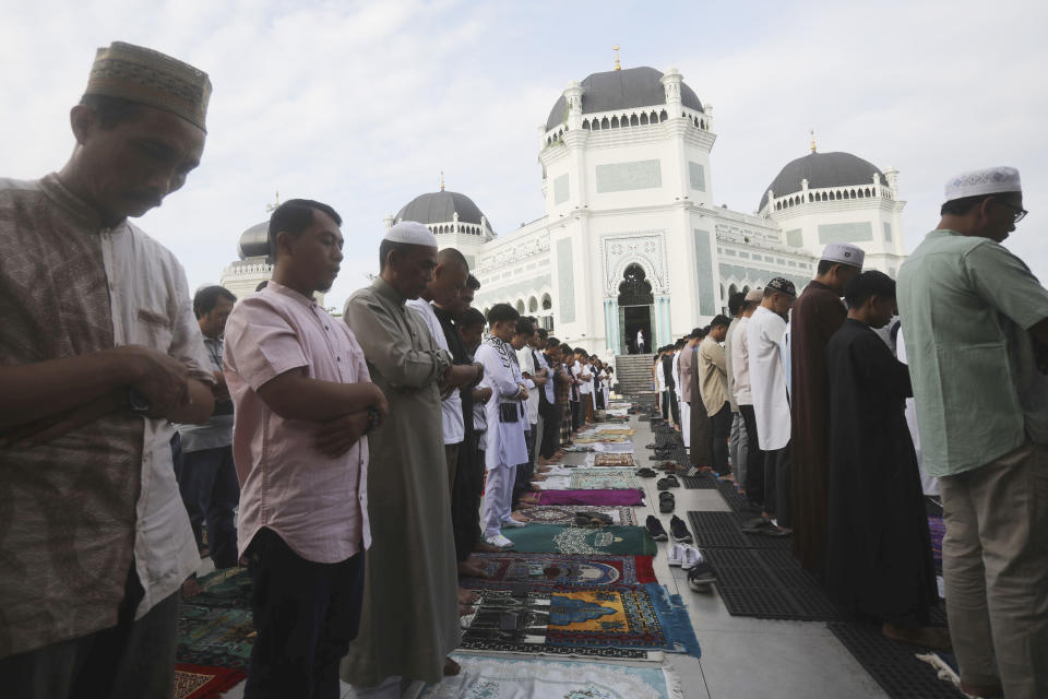 Muslims perform a morning prayer marking the Eid al-Adha holiday in front of Al Mashun Great Mosque in Medan, Indonesia, Thursday, June 29, 2023. Muslims around the world will celebrate Eid al-Adha, or the Feast of the Sacrifice, slaughtering sheep, goats, cows and camels to commemorate Prophet Abraham's readiness to sacrifice his son Ismail on God's command. (AP Photo/Binsar Bakkara)