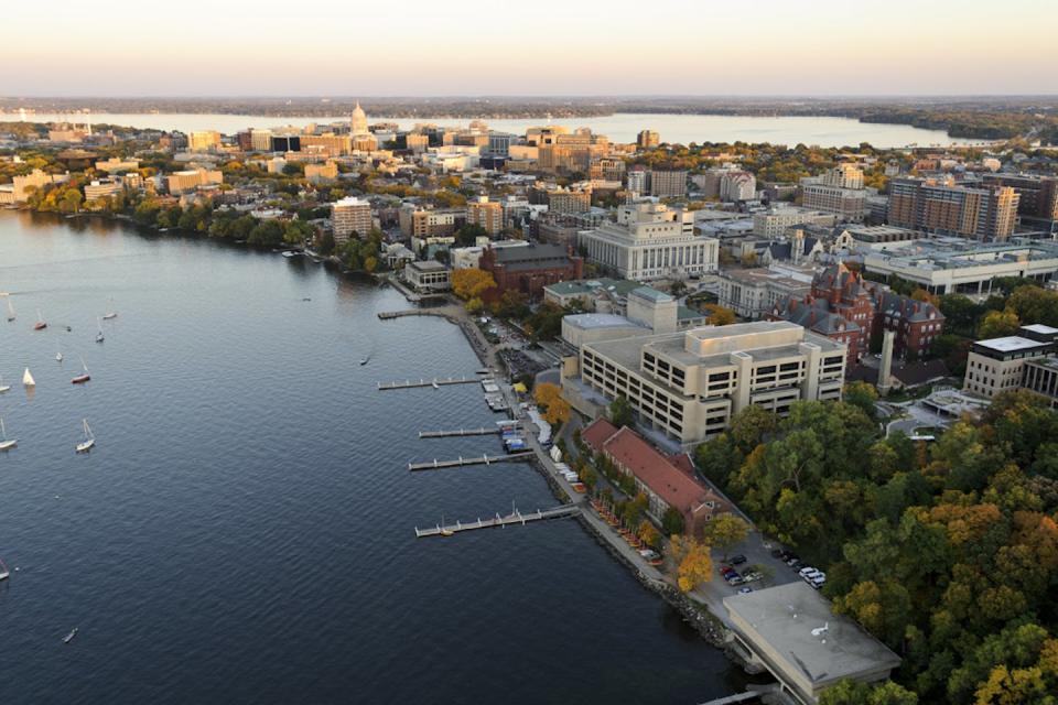 An aerial photo shows the Lake Mendota shoreline and the University of Wisconsin-Madison campus.