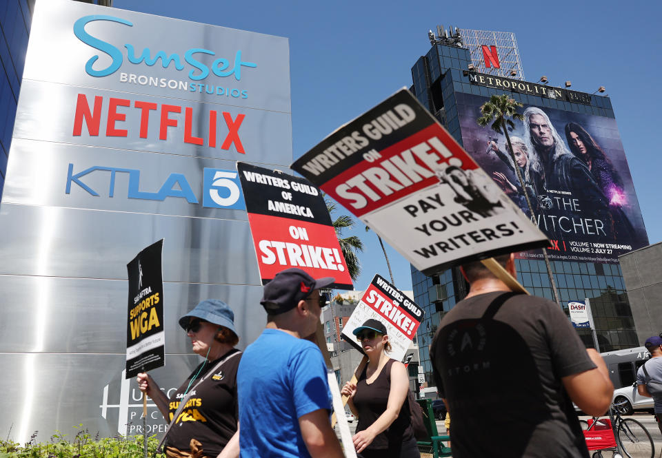 LOS ANGELES, CALIFORNIA - JULY 11: People carry signs as SAG-AFTRA members walk the picket line in solidarity with striking WGA (Writers Guild of America) workers outside Netflix offices on July 11, 2023 in Los Angeles, California. Industry insiders concerned about the possibility of a potential actors’ strike will have to wait a little bit longer to know for sure. SAG-AFTRA and top studios and streamers have agreed to extend their current contract negotiations until July 12 at 11:59 p.m. (Photo by Mario Tama/Getty Images)