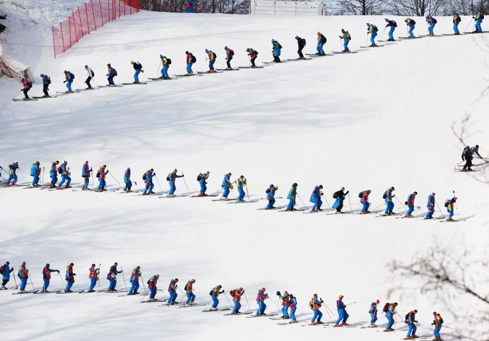 Volunteers smooth the piste during the Men's Alpine Skiing Super-G at the Rosa Khutor Alpine Center during the Sochi Winter Olympics on February 16, 2014. 