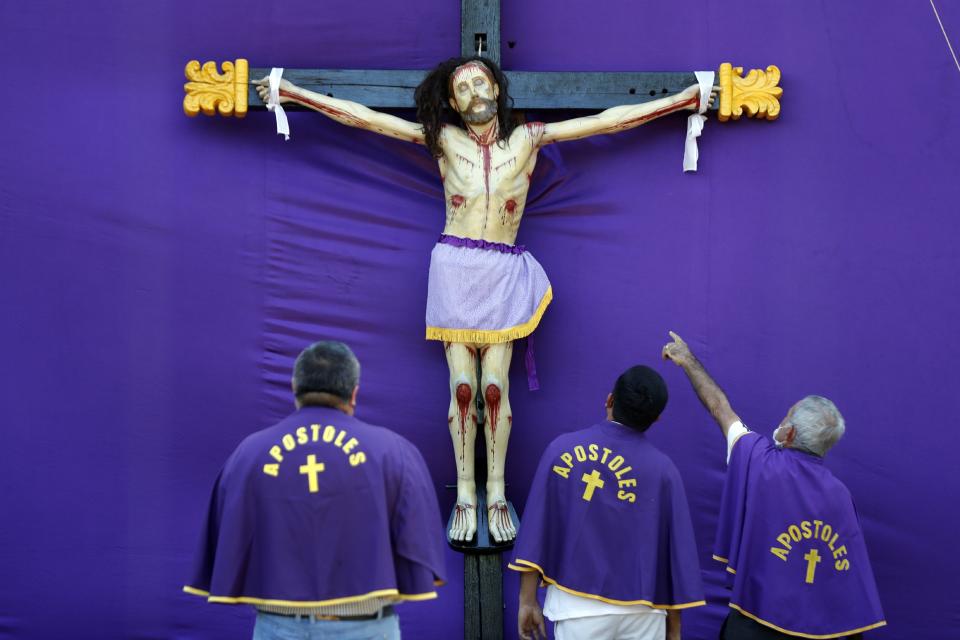 Catholic faithful reenact the crucifixion of Jesus Christ in a Passion Play on the plaza of the Our Lady of Candelaria church that remained closed to the public due to coronavirus restrictions, in Capiata, Paraguay, Friday, April 2, 2021. As deaths related to COVID-19 increase daily the government decreed a preventive lockdown during Holy Week. (AP Photo/Jorge Saenz)