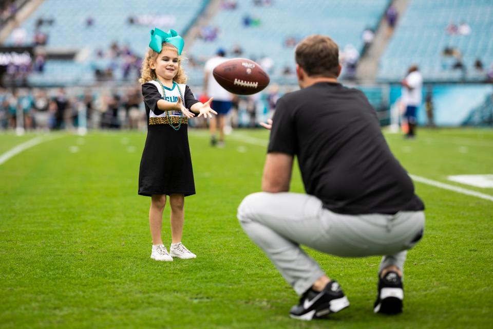 Jaguars' offensive coordinator Press Taylor plays catch with his oldest daughter, Teale, prior to their 2022 home game against the Baltimore Ravens.