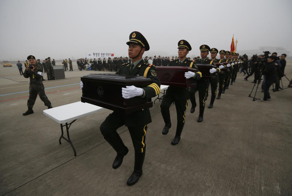 Chinese honor guards holding caskets containing the remains of Chinese soldiers take part in the handing over ceremony of the remains at the Incheon International Airport in Incheon, South Korea Friday, March 28, 2014. The remains of more than 400 Chinese soldiers killed during the 1950-53 Korean War were transferred from the temporary columbarium in South Korea to the airport to return home for permanent burial. (AP Photo/Kim Hong-ji, Pool)