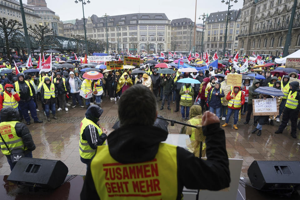 Demonstrators attend a rally of the trade union Ver.di at the Rathausmarkt, in Hamburg, Germany, Thursday, March 23, 2023. German unions are calling on thousands of workers across the country's transport system to stage a one-day strike on Monday that is expected to bring widespread disruption to planes, trains and local transit. Writing on jacket reads in German; "Together we can do more". (Marcus Brandt/dpa via AP)