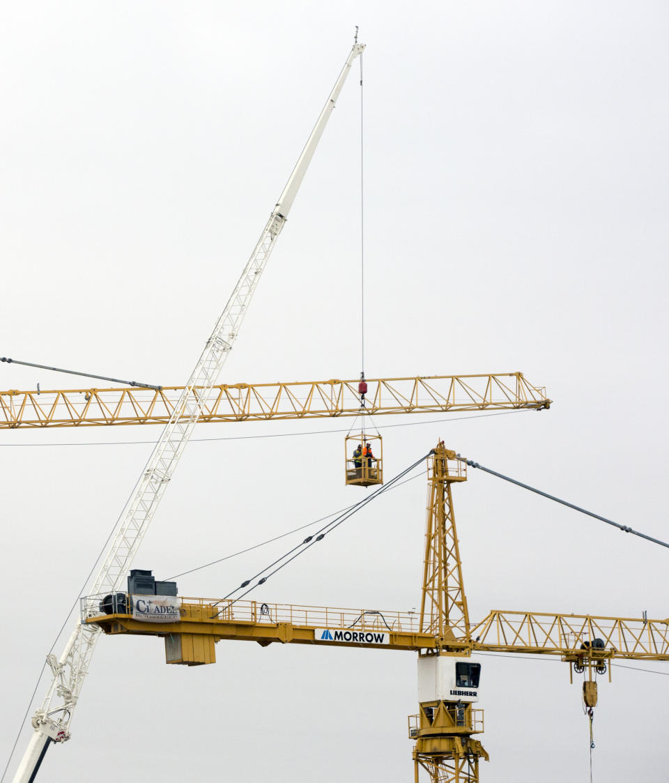 Workers go up to inspect the two unstable cranes before implosion at the Hard Rock Hotel construction site in New Orleans, Friday, Oct. 18, 2019. The Hard Rock Hotel partially collapsed last week. (Sophia Germer/The Advocate via AP)/