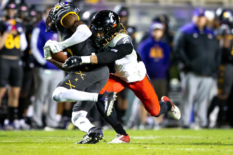 Cincinnati Bearcats safety Bryan Cook (6) tackles East Carolina Pirates quarterback Ryan Stubblefield (6) in the second half of the NCAA football game at Dowdy-Ficklen Stadium in Greenville, NC, on Friday, Nov. 26, 2021. Cincinnati Bearcats defeated East Carolina Pirates 35-13. 