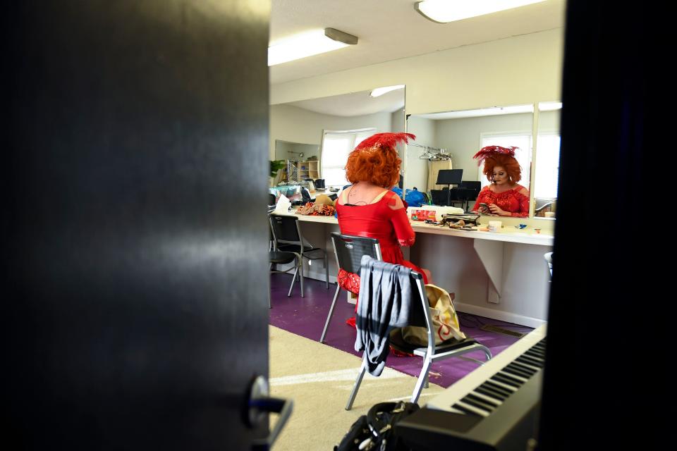 Drag performer Clay "Delighted Tobehere" Smith plays on his phone while waiting to go on stage at the Hendersonville Theatre in Hendersonville, N.C., on Friday, June 23, 2023. Smith wrote an autobiographical, theatrical comedy drag show during the COVID-19 pandemic honoring the 20th year performing in drag.  