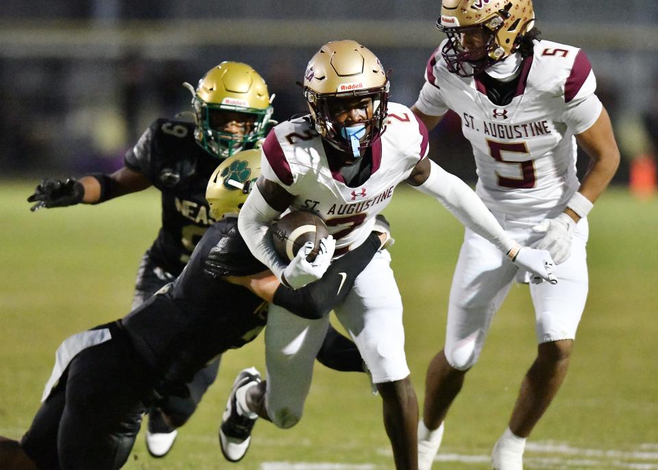 St. Augustine's Carl Jenkins Jr. (2) fights through Nease Panthers defenders on a first quarter run. The St. Augustine Yellow Jackets traveled to Nease High School's Panther Stadium for Friday night's Saint Johns County high school football rivalry game October 6, 2023.