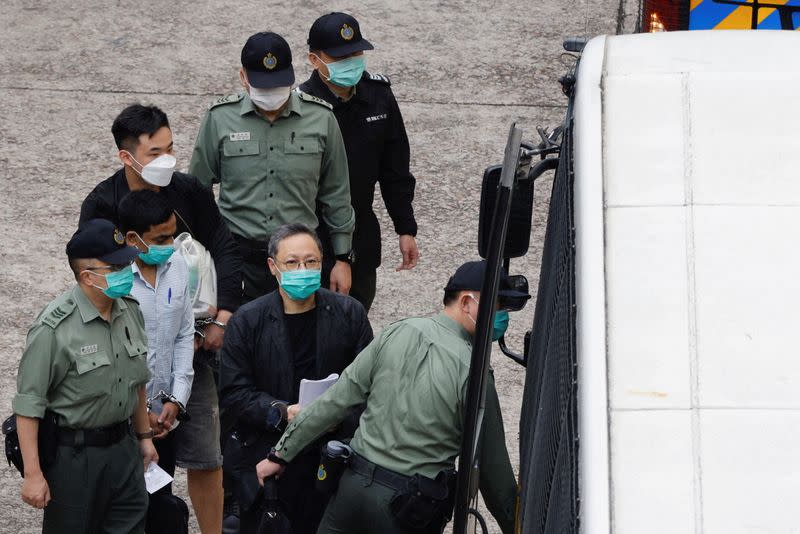 FILE PHOTO: Pro-democracy activist Benny Tai walks to a prison van to head to court over the national security law charge, in the early morning, in Hong Kong