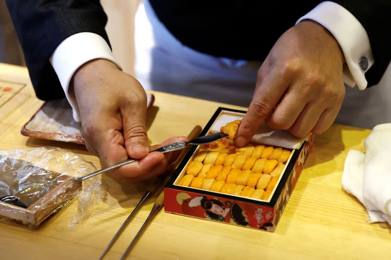 Kazuyuki Tanioka, the owner of Japanese cuisine Toya restaurant, prepares a sushi dish with sea urchins sourced within China, during an interview with Reuters, in Beijing