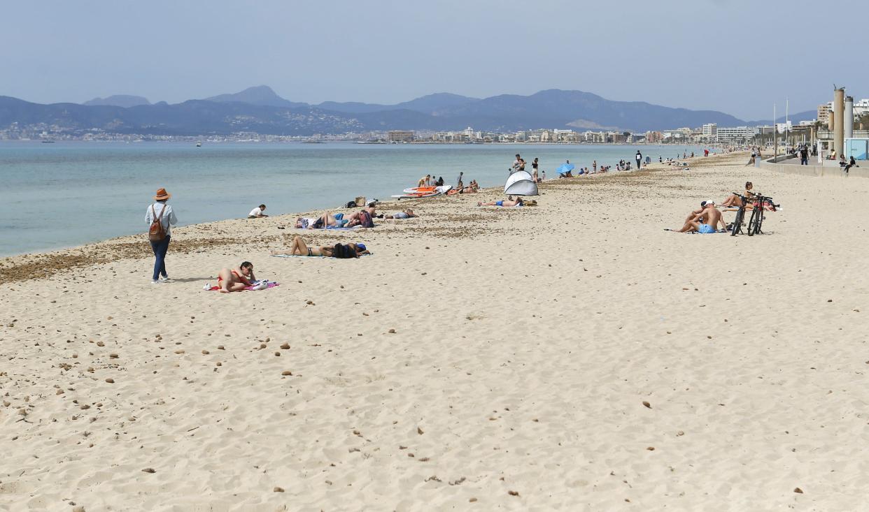 <p>People sunbathe on Playa de Palma beach in Palma de Mallorca, Spain</p> (REUTERS)