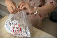A woman holds a plastic bag of OxyContin tablets sold in China in southern China's Hunan province on Sept. 24, 2019. Representatives from the Sacklers' Chinese affiliate, Mundipharma, tell doctors that OxyContin is less addictive than other opioids — the same pitch that their U.S. company, Purdue Pharma, admitted was false in court more than a decade ago. (AP Photo/Mark Schiefelbein)