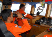 A member of Indonesian National Search And Rescue Agency (BASARNAS) uses a binocular to scan the horizon during a search operation for the missing Malaysia Airlines Boeing 777 conducted on the waters of the Strait of Malacca off Sumatra island, Indonesia, Wednesday, March 12, 2014. Malaysia asked India to join the expanding search for the missing Boeing 777 near the Andaman Sea, far to the northwest of its last reported position and a further sign Wednesday that authorities have no idea where the plane might be more than four days after it vanished. (AP Photo/Heri Juanda)