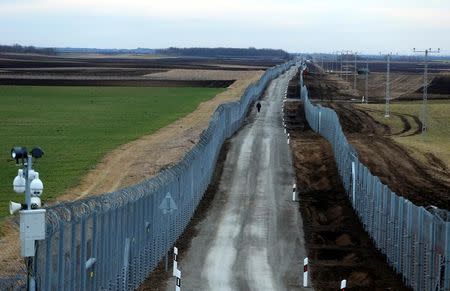 FILE PHOTO: A Hungarian policeman patrols the Hungary-Serbia border, which was recently fortified by a second fence, near the village of Gara, Hungary March 2, 2017. REUTERS/Laszlo Balogh