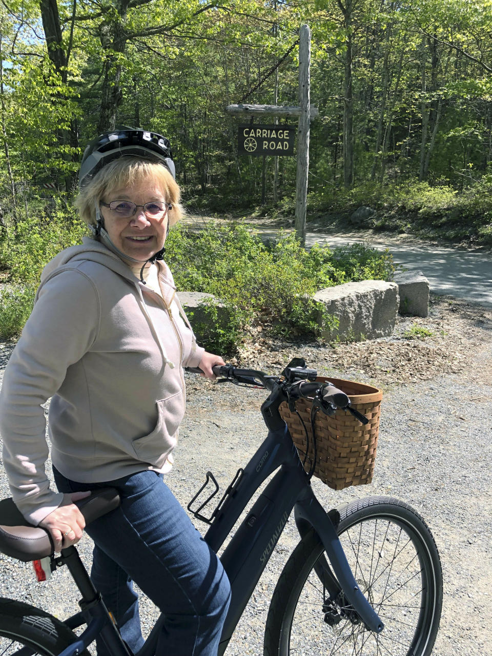 In this June 8, 2019 photo, Janice Goodwin stops her electric-assist bicycle gate near a carriage path in Acadia National Park at Bar Harbor, Maine. Electric-assist bikes are allowed on paved roads but are banned on carriage path and bicycle paths in national parks. (AP Photo/David Sharp)