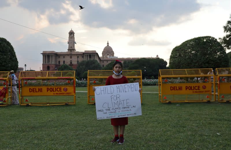 Licypriya Kangujam holds a poster during a protest demanding to pass a climate change law outside the parliament in New Delhi