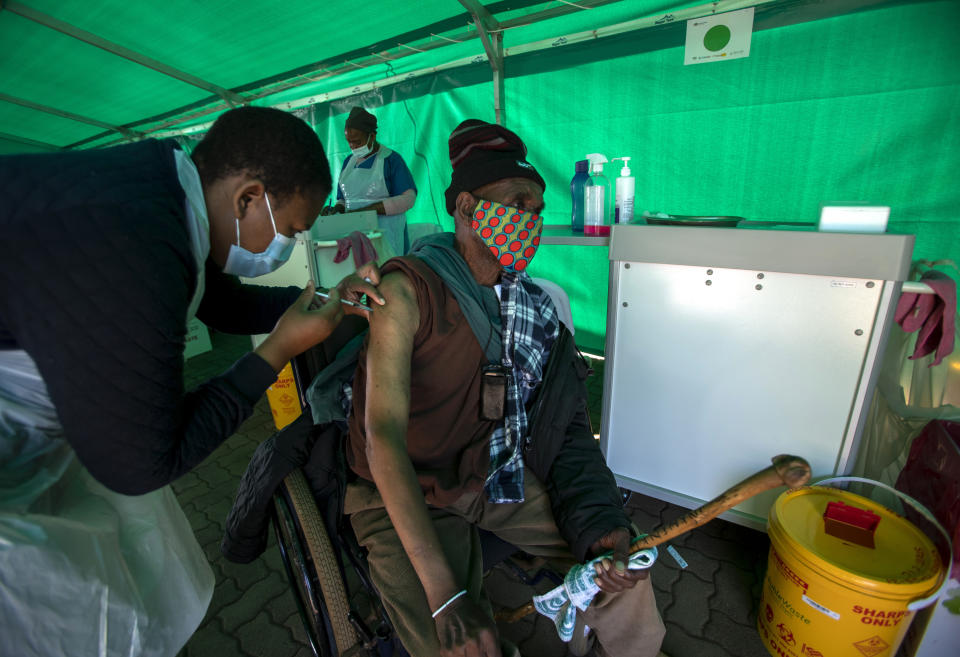 A health worker vaccinates a retiree with a the first dose of the Pfizer coronavirus vaccine inside a tent, during a mass vaccination program for the elderly at the clinic outside Johannesburg, South Africa, Monday, May 24, 2021. South Africa aims to vaccinate 5 million of its older citizens by the end of June. (AP Photo/Themba Hadebe)