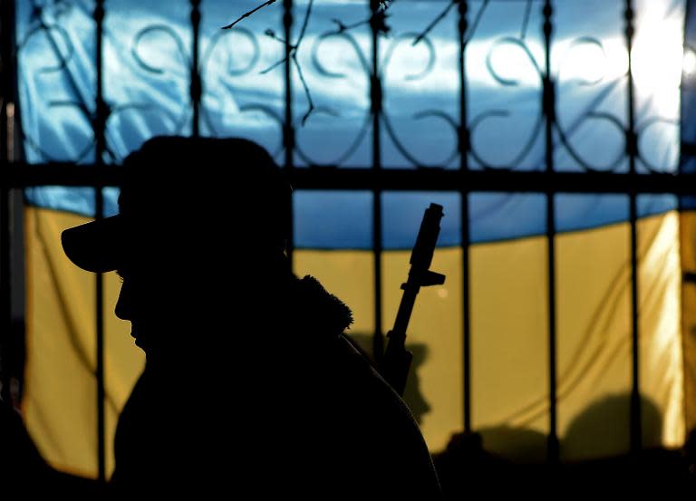 The silhouette of a Ukrainian soldier is seen against a Ukrainian flag in Sevastopol, on March 3, 2014