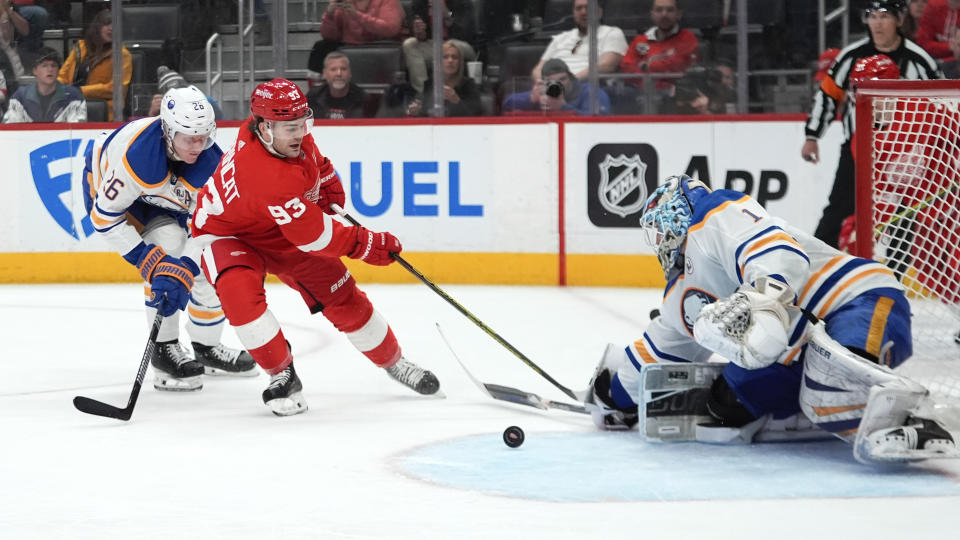 Buffalo Sabres goaltender Ukko-Pekka Luukkonen (1) stops a Detroit Red Wings right wing Alex DeBrincat (93) shot as Rasmus Dahlin (26) defends in the second period of an NHL hockey game Sunday, April 7, 2024, in Detroit. (AP Photo/Paul Sancya)