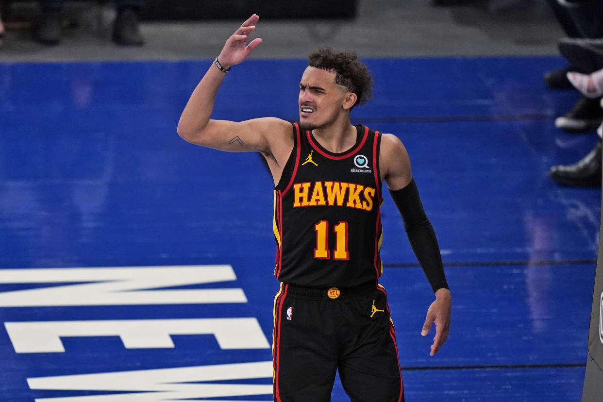 Trae Young reacts and throws an arm up in the air.