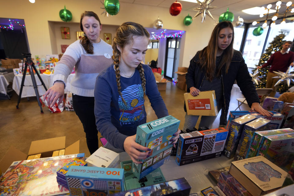 Molly Armbrecht, center, arranges toys at The Toy Store, a free-referral based toy store Thursday, Dec. 7, 2023, in Nashville, Tenn. The facility is co-founded by Brad Paisley and Kimberly Williams-Paisley. The couple also started The Store, a free-referral based grocery store they opened in partnership with Belmont University in March 2020. (AP Photo/Mark Humphrey)