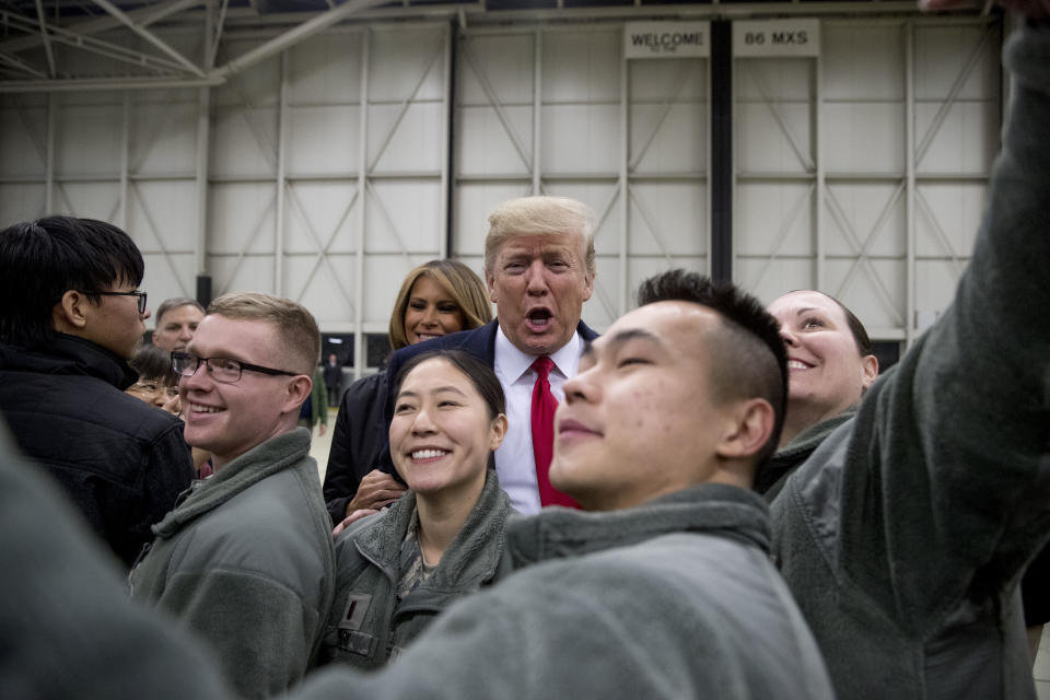 FILE - In this Thursday, Dec. 27, 2018 file photo, President Donald Trump, center, and first lady Melania Trump, center left, greet members of the military at Ramstein Air Base, Germany. Germany's defense minister Annegret Kramp-Karrenbauer is warning that U.S. President Donald Trump's reported plans to withdraw more than a quarter of the American troops out of Germany could weaken not only the NATO alliance but the U.S. itself. (AP Photo/Andrew Harnik)