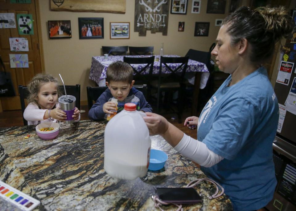 Jeannie Arndt pours milk for Paisley Conkey, 4, left, and Cashton Alarie, 4, on Oct. 5 at Little Racecar Daycare in Wisconsin Rapids.