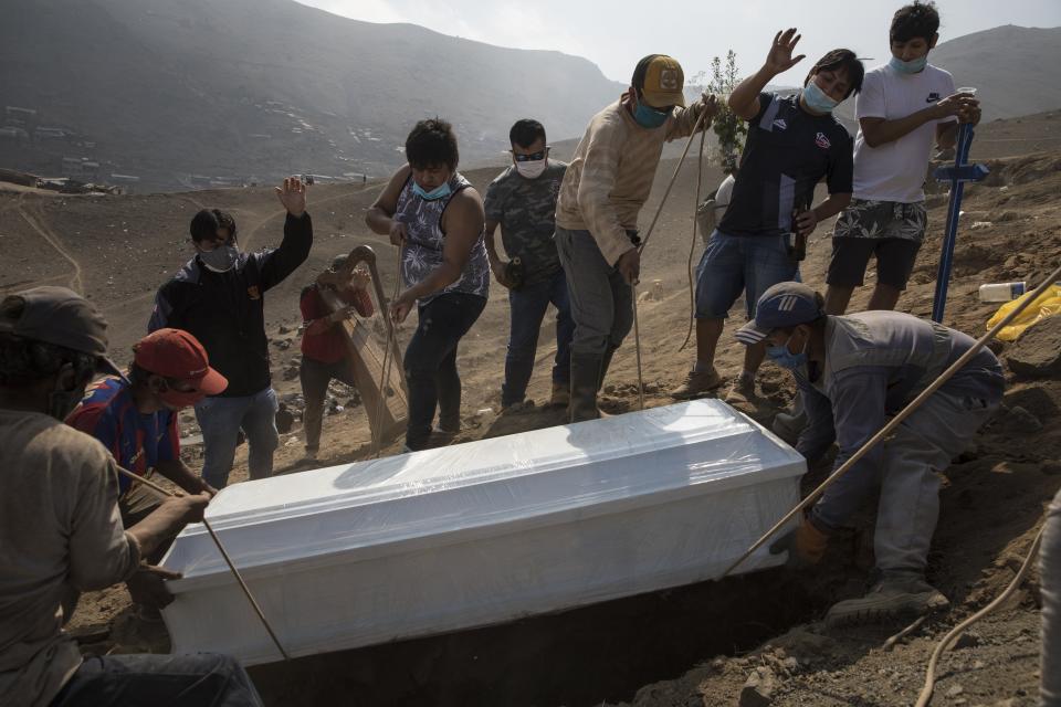 Relatives bury their 85-year-old grandfather Lupicino Fernandez who died of the new coronavirus, at the Nueva Esperanza cemetery on the outskirts of Lima, Peru, Wednesday, May 27, 2020. (AP Photo/Rodrigo Abd)