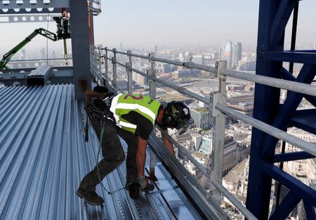 A worker installs an edge trim on the AXA IM - Real Assets Twentytwo building in London, Britain April 20, 2018. Picture taken April 20, 2018. REUTERS/Darren Staples